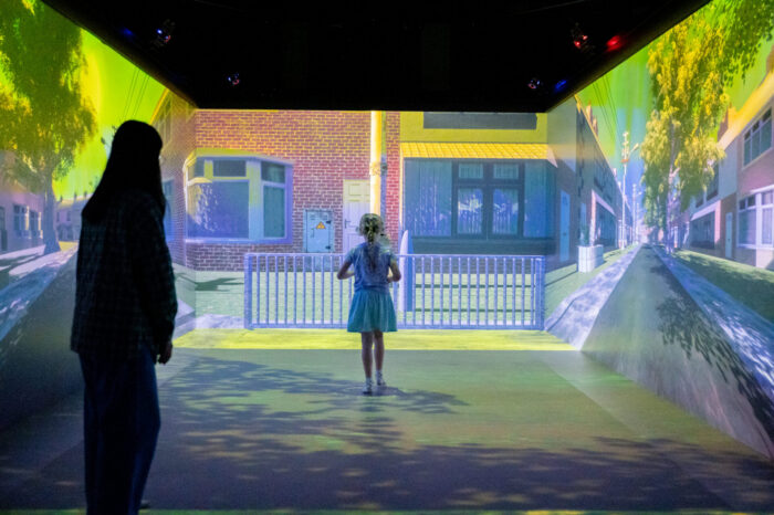 A child in an immersive walking simulator crossing a virtual road